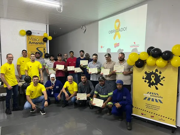 Equipe e colaboradores com certificados ao final da ação de Maio Amarelo na BRF Jataí, sob o banner “Quem respeita as regras de trânsito, preserva vidas”.