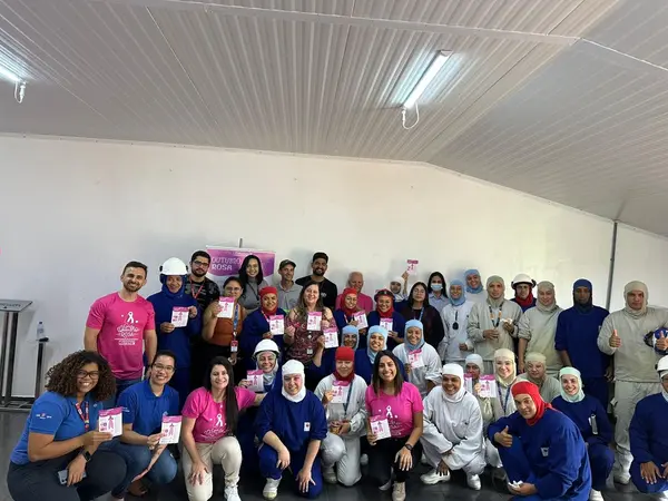 Colaboradores da BRF Jataí reunidos com folhetos de conscientização durante a ação de Outubro Rosa.